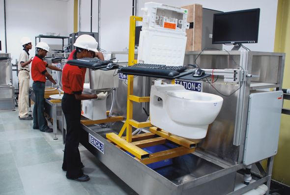 Three Kohler Co. employees work in a sustainability plant, testing toilets