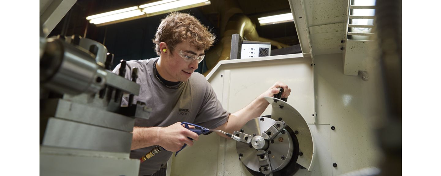 An apprentice working with Kohler Engines gets hands-on experience as he uses a tool
