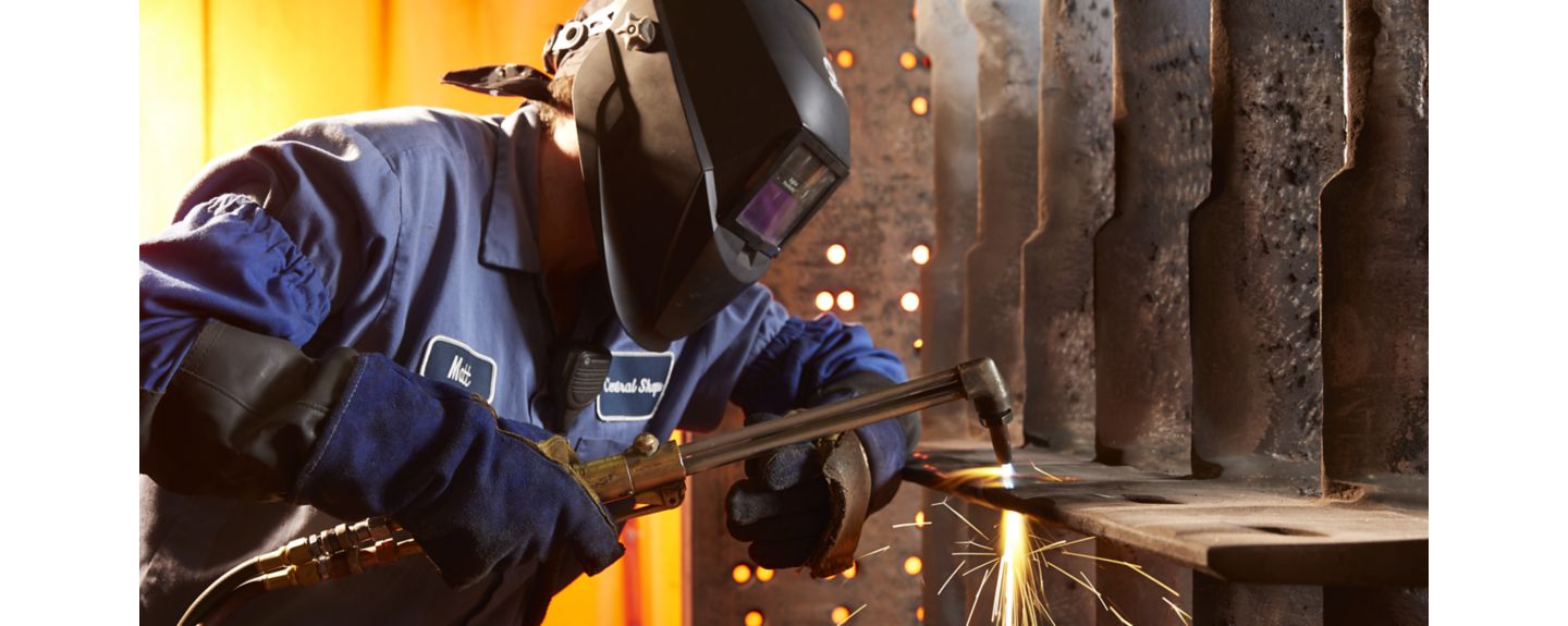 A machinist in full welding safety gear welds at a Kohler Co. facility.