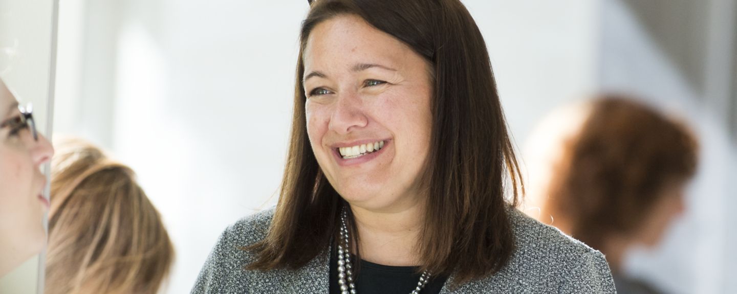 An administrative professional at Kohler Co. smiles as she talks with other employees