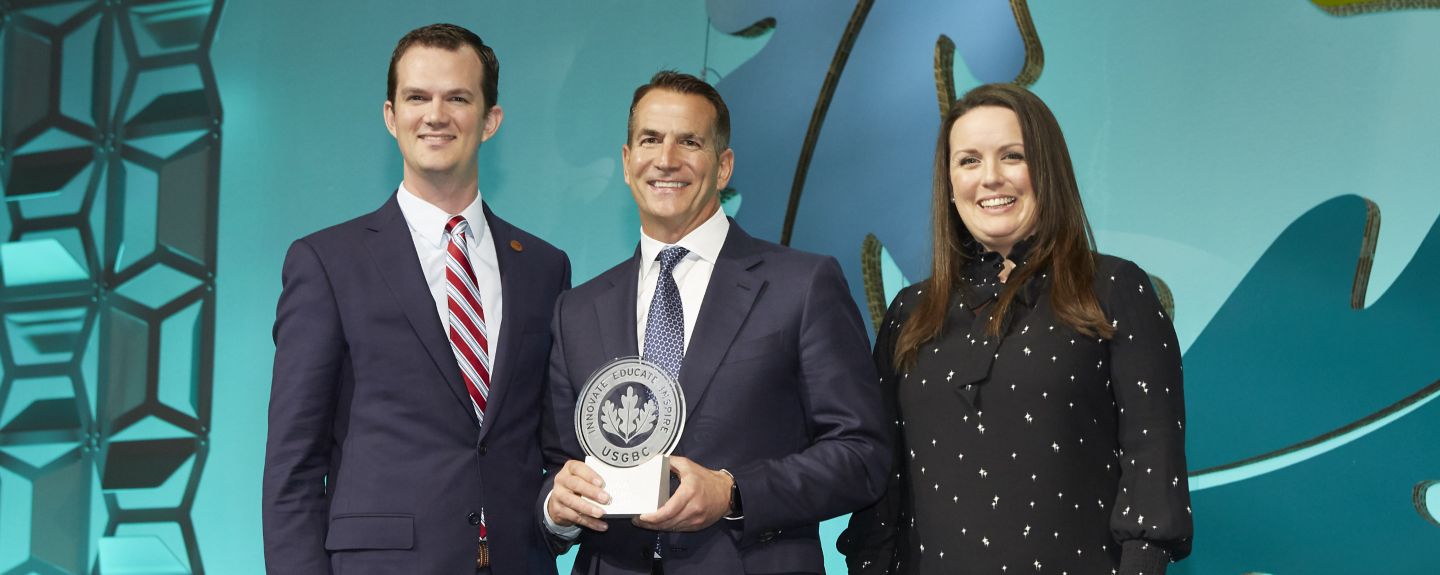 David Kohler and two other people accept an award that says innovate, educate, inspire