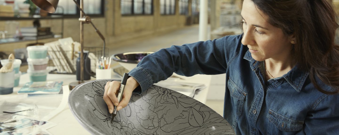 A Kohler Co. employee who works in product and facility design draws a pattern on an Artist Edition sink.