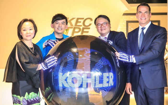 Angel Yang stands with David Kohler, Larry Yuen and another man at a big orb that says KOHLER
