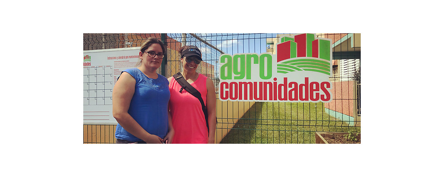 Vanessa Quiñones, Massage Therapist at Kohler Waters Spa, stands with another woman in front of an Agros Comunidads sign
