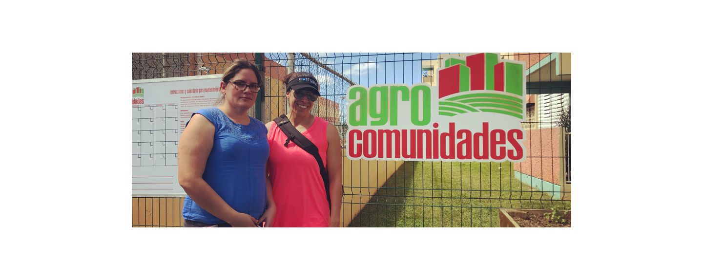 Vanessa Quiñones, Massage Therapist at Kohler Waters Spa, stands with another woman in front of an Agros Comunidads sign