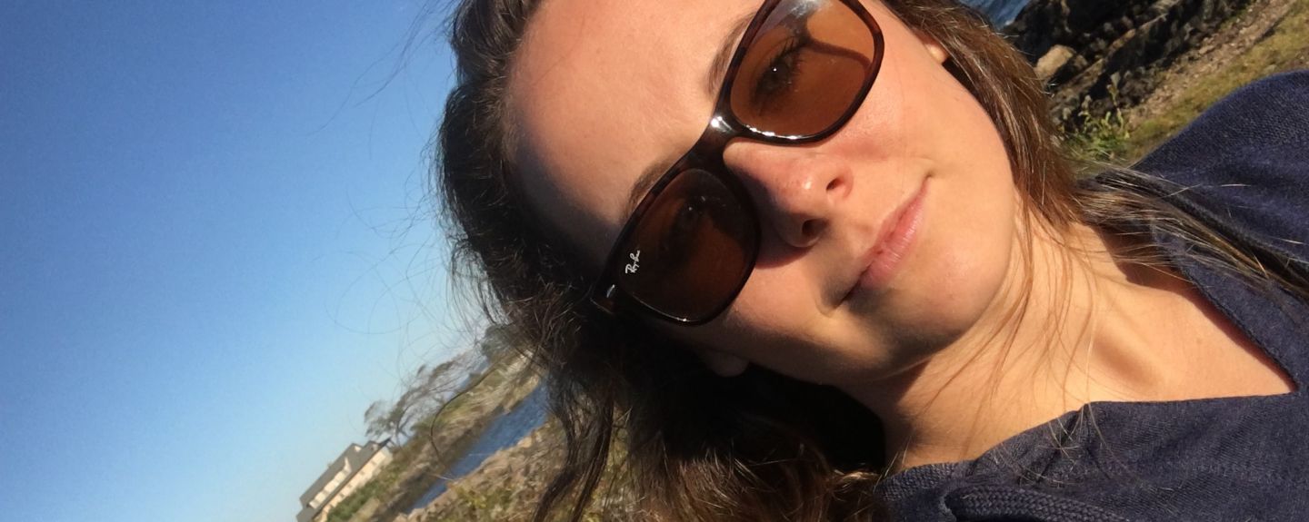 Megan Kolb, an area associate on Kohler Co.'s Retail Faucets marketing team, stands in the sun in front of the shoreline.