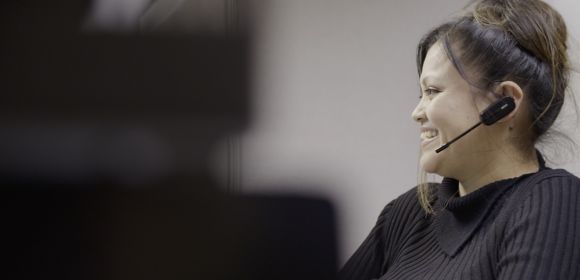 A customer service employee at Kohler Co. smiles as she talks to a customer via her headset