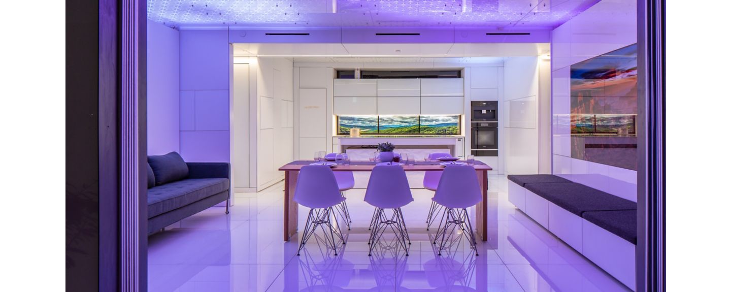 The solar-powered FutureHAUS, a modern model home including a dining area and seating.