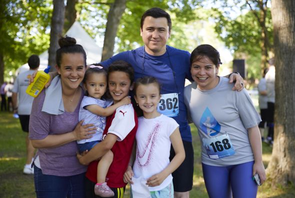 A family gathers with their arms around each other as the father, a Kohler Co. employee, and one child have just finished a fundraising run or walk together