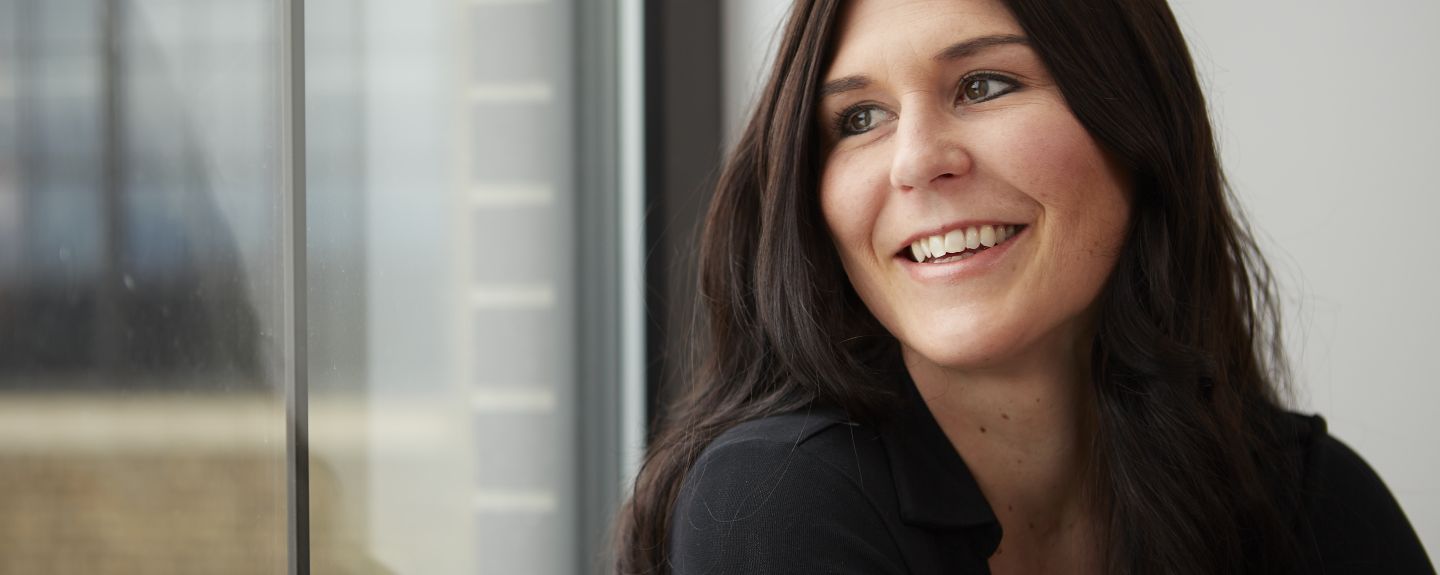 Jen Rindt, smiles as she looks out the window toward a Kohler manufacturing facility