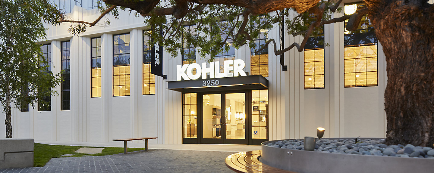 A photo taken from outside shows the front entrance to a LEED-certified KOHLER showroom.