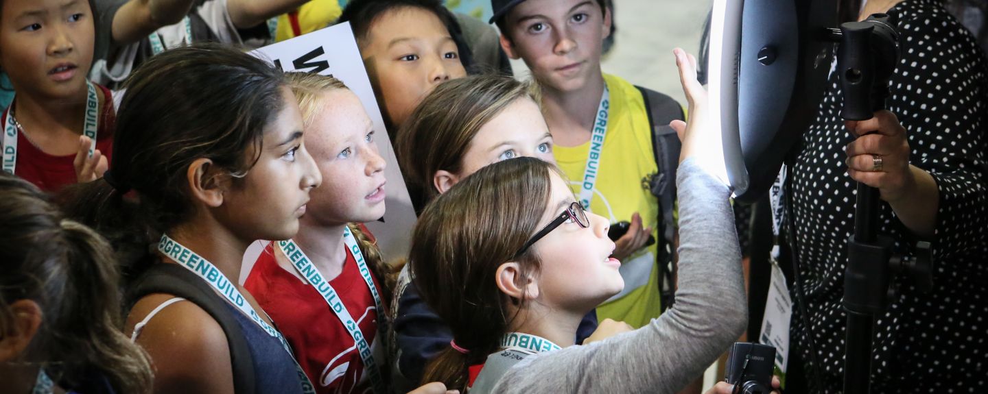 A group of kids use a touchscreen to learn about sustainability