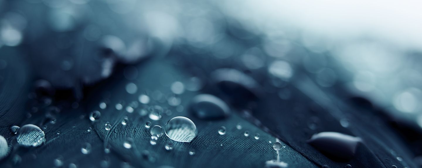 Water beaded up on a silver surface with the KOHLER logo over it