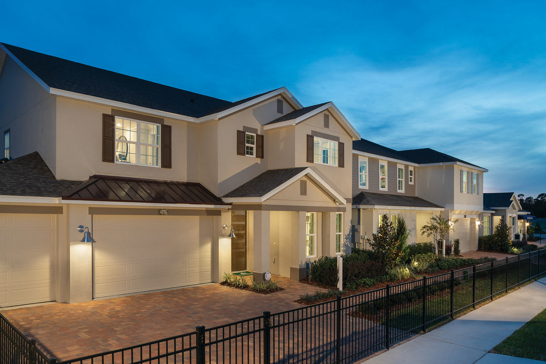 Image of model streetscape in Hanover Lakes displaying home with lights on in the evening.