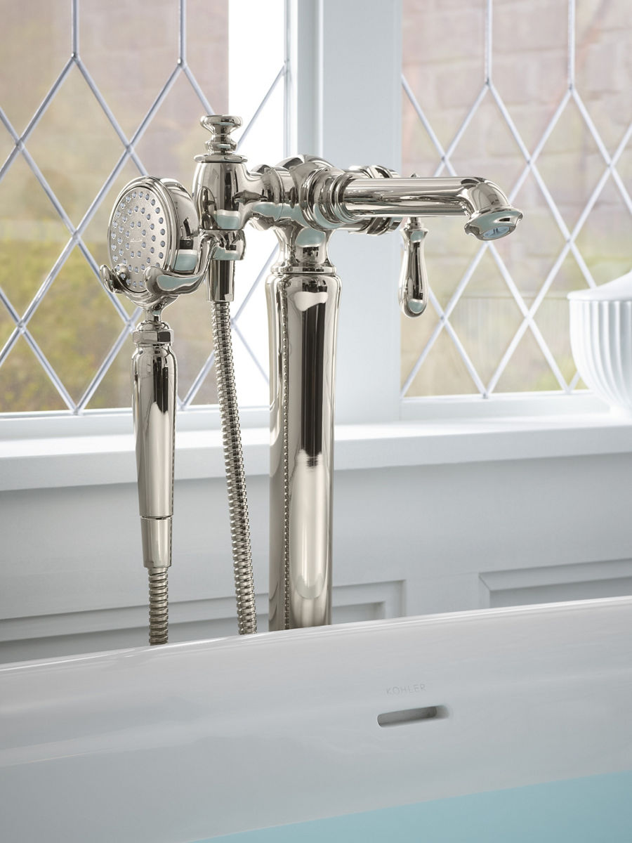 Close up of a Memoirs bath filler and handshower in polished nickel above a filled bath that sits in front of a leaded-glass window.