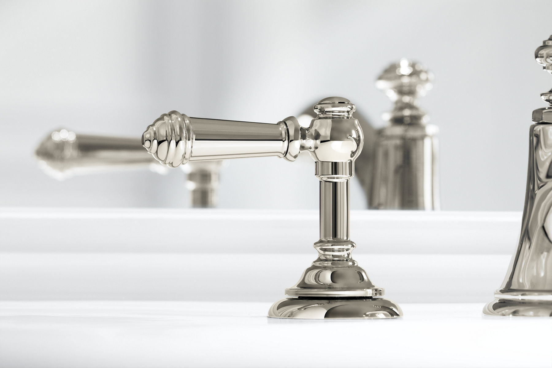 Gros plan sur les poignées à levier de lavabo de salle de bain déployé Artifacts de KOHLER au fini nickel poli Vibrant