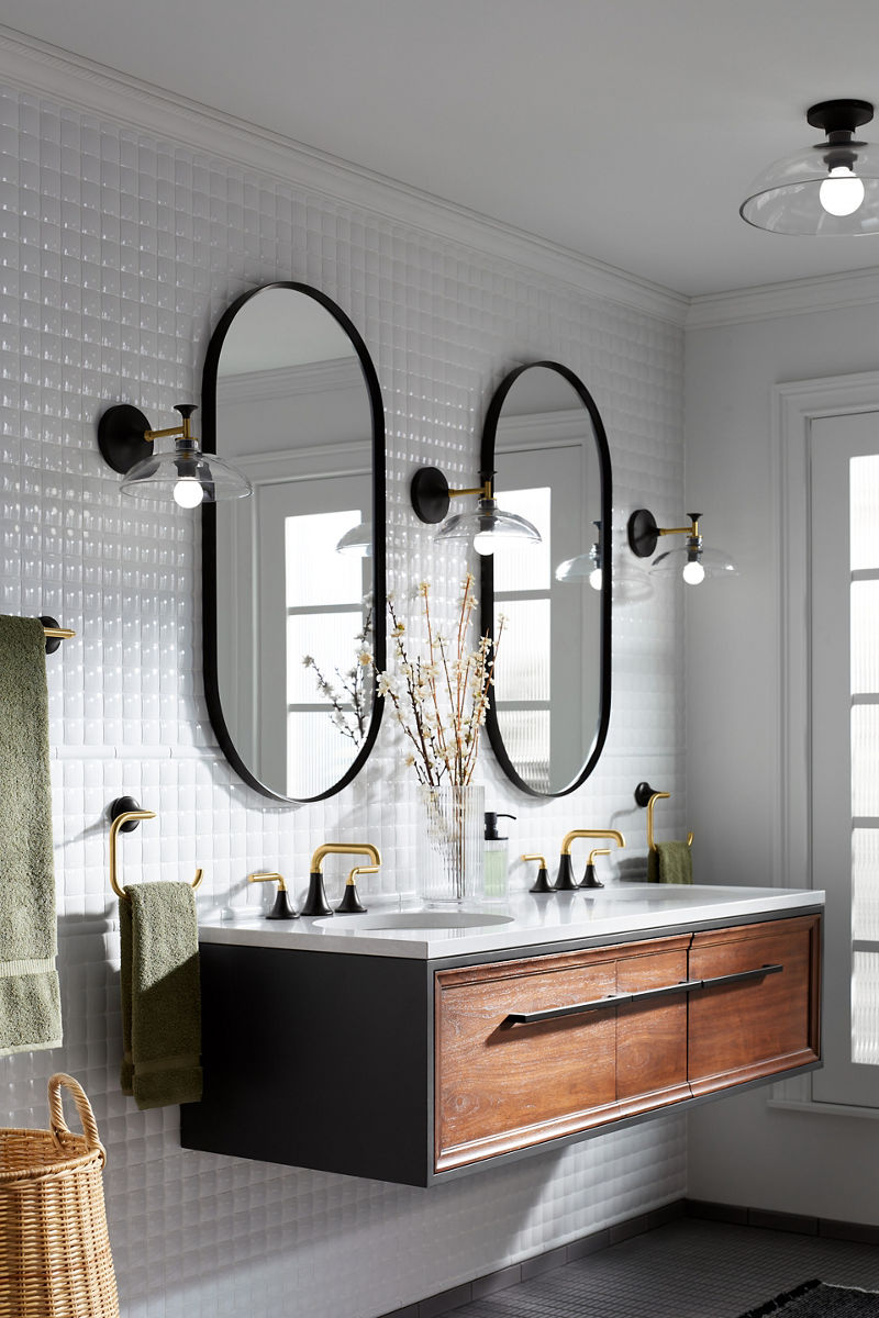 Green towels hang beside a KOHLER Lodern wall-mounted double vanity with Tone faucets and Essential capsule mirrors.