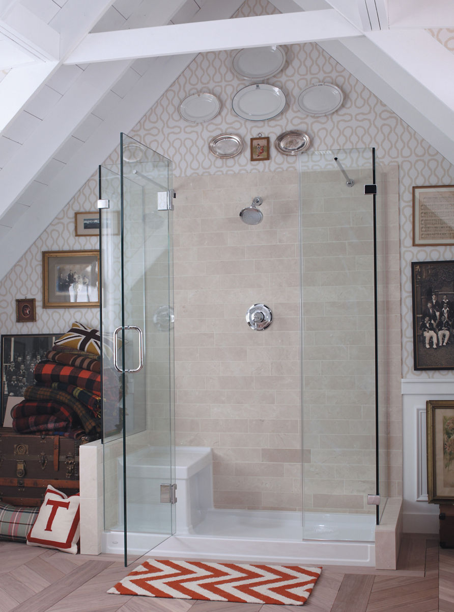 Une douche de plain-pied dans une salle de bain mansardée avec panneaux de douche et porte en verre, mur arrière en carrelage havane et base de douche blanche Tresham de KOHLER.