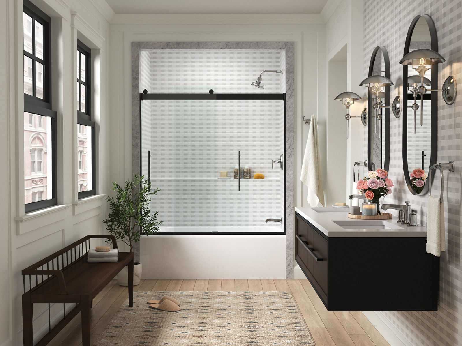 Portes de douche coulissantes en verre KOHLER au bout d’une salle de bain blanche avec deux fenêtres et un banc noir d’un côté et deux miroirs ovales avec un meuble-lavabo mural noir de l’autre côté.