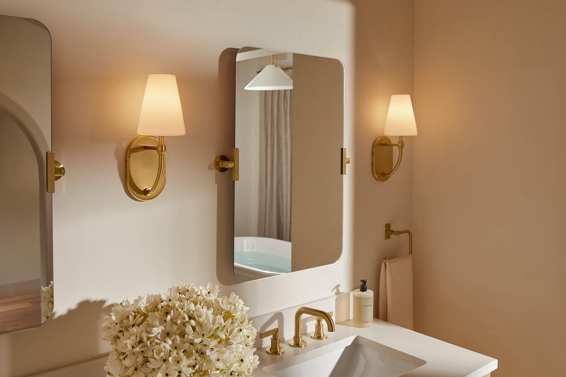 Two sconces installed in a bathroom from the Kohler Kernen lighting collection.
