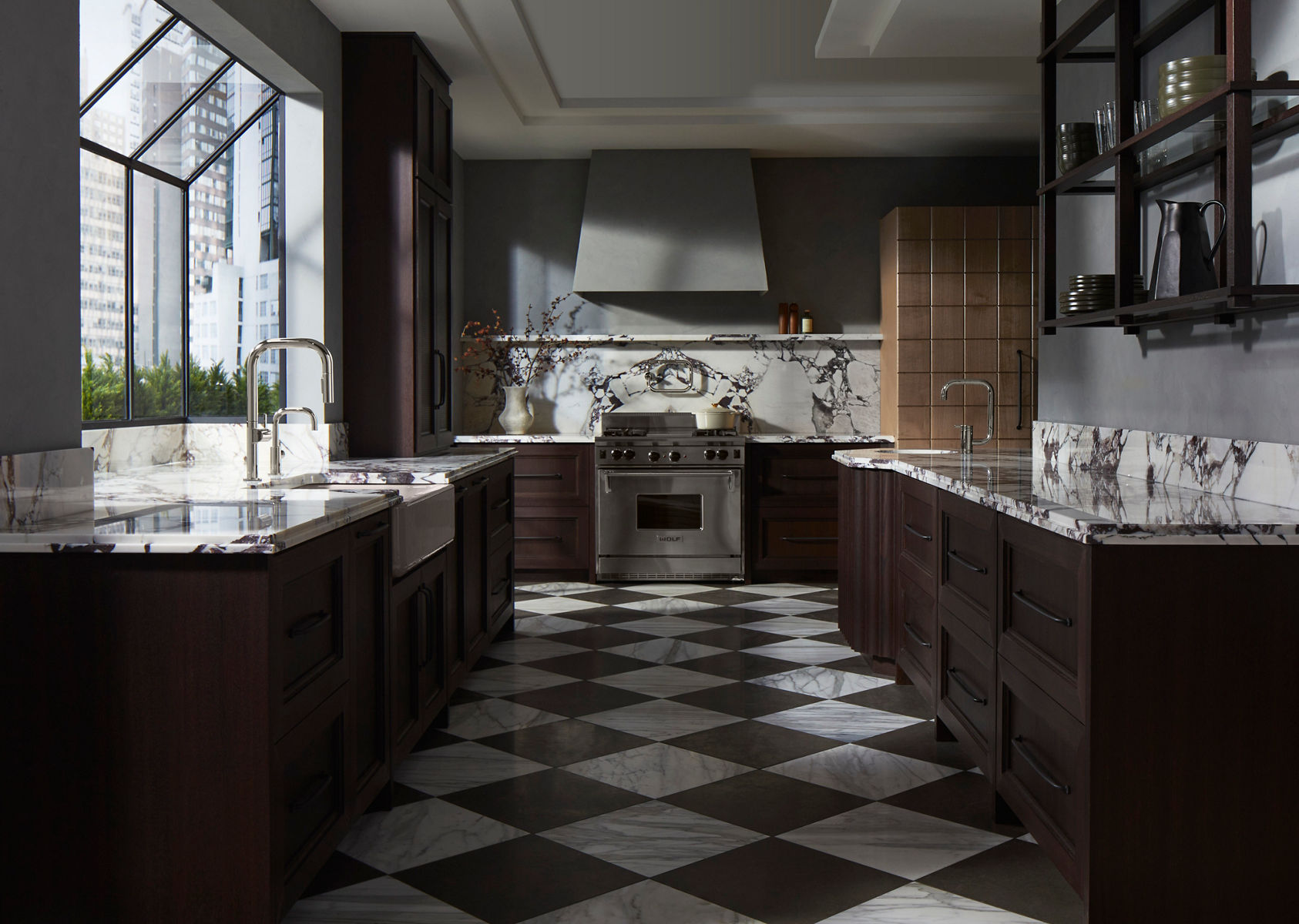 A kitchen with dark wood cabinets on the left, right and background, with a marbled stone counter tops and back splashes.