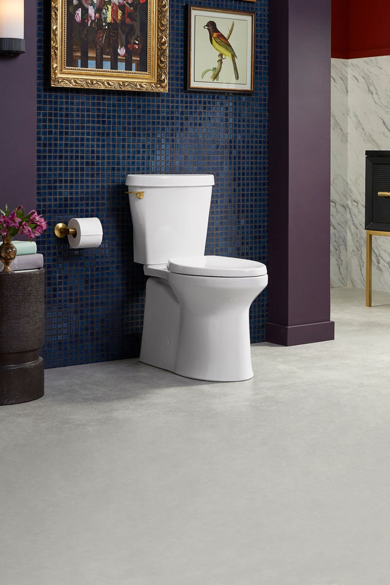 White toilet set against a blue tiled wall in a modern bathroom with marble and dark accent details.