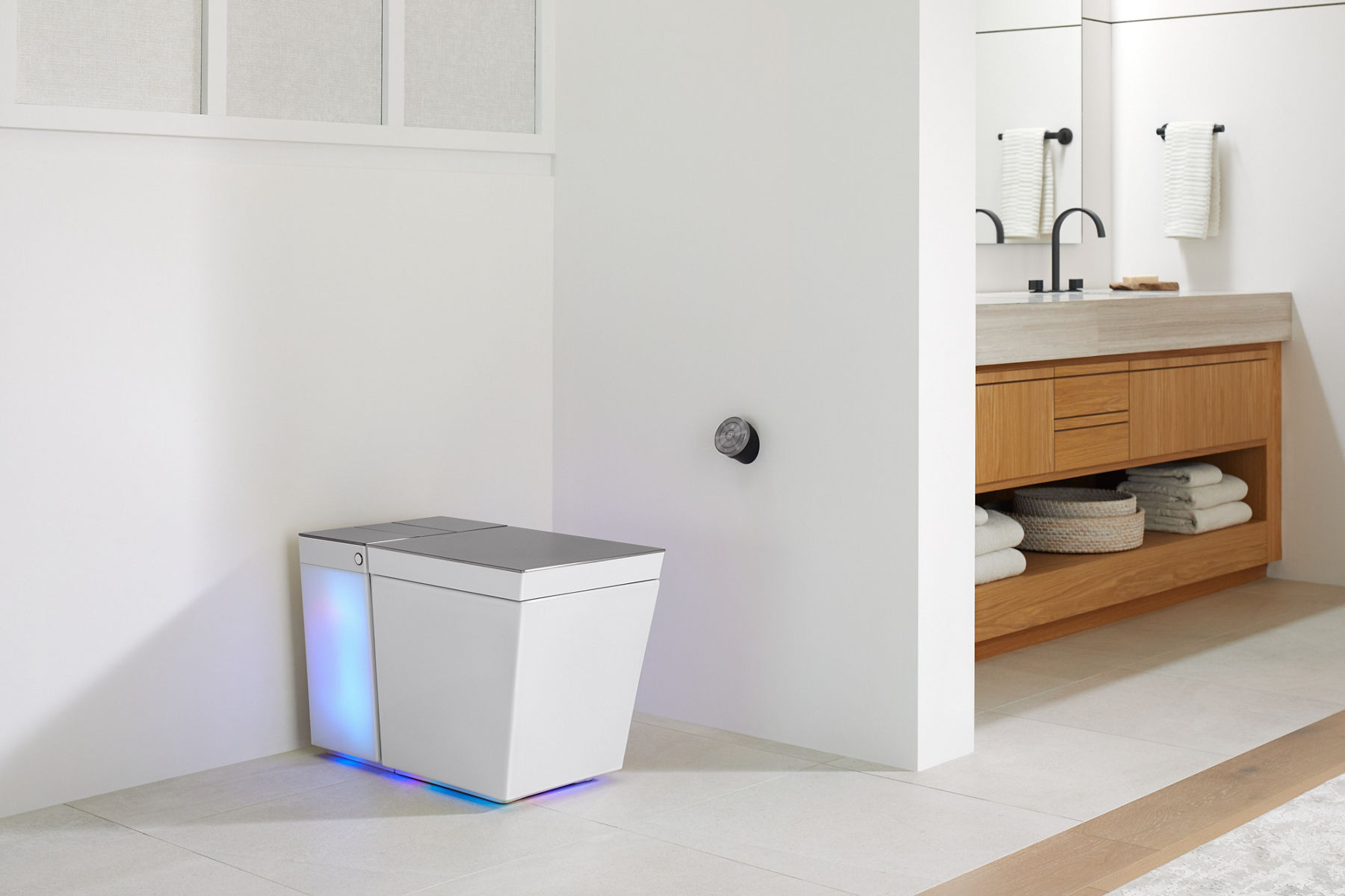 A white Numi 2.0 toilet with the rear portion illuminated, set in a bathroom with white walls and floors.