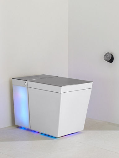 A white Numi 2.0 toilet with the rear portion illuminated, set in a bathroom with white walls and floors.