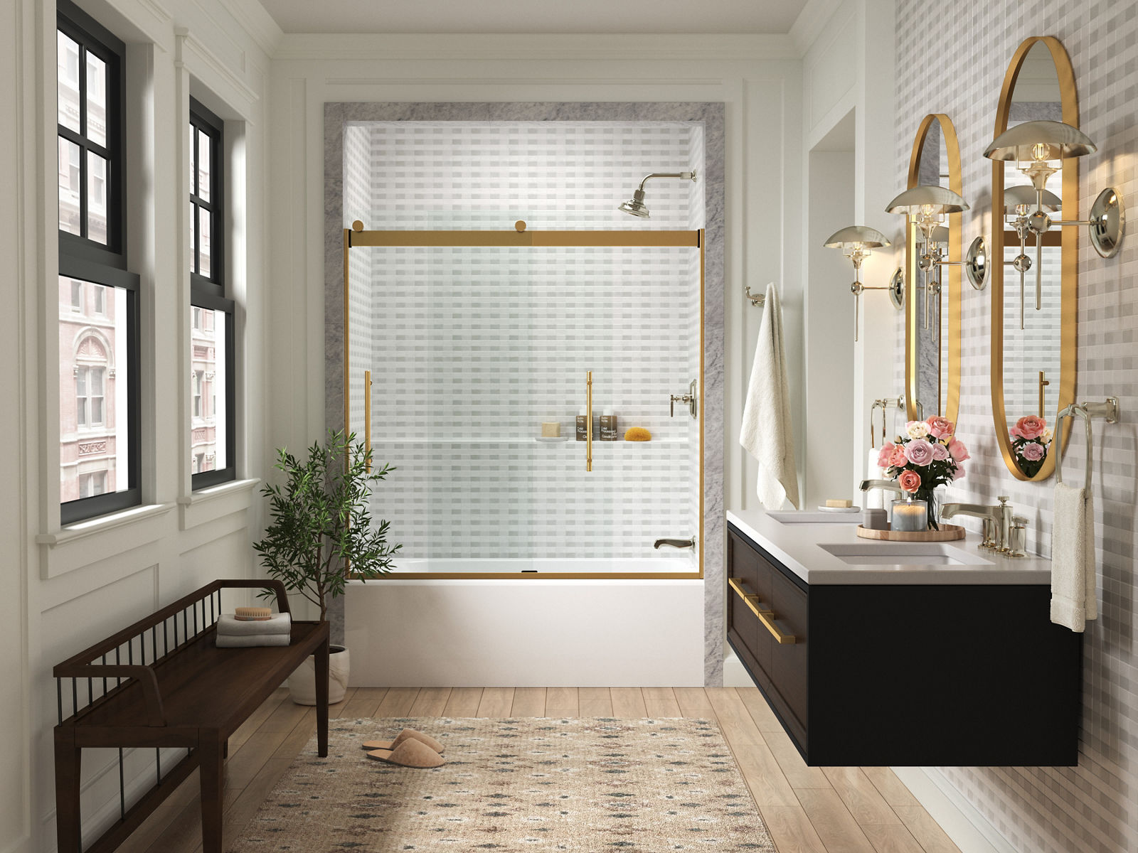Portes de douche coulissantes en verre KOHLER avec garniture dorée à l’extrémité d’une salle de bain blanche avec un meuble-lavabo mural noir et deux miroirs ovales dorés fixés au mur.