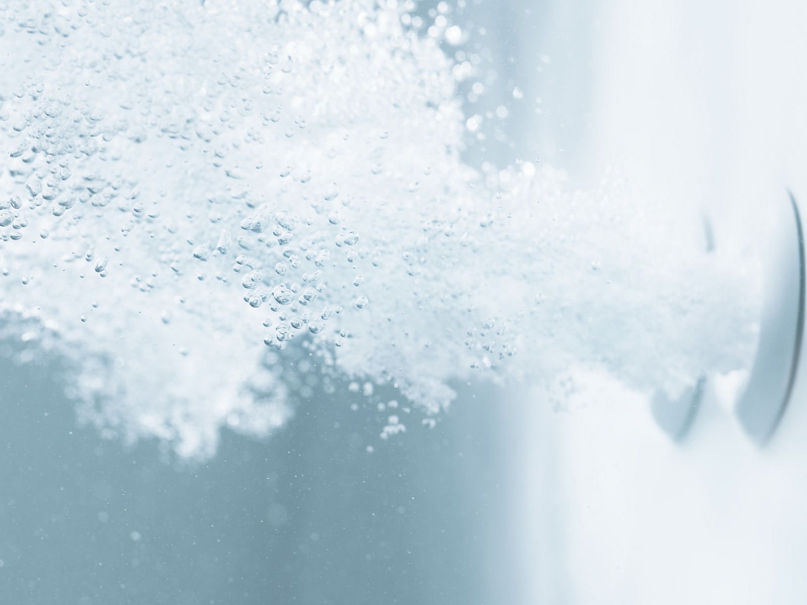 Air bubbles flow in water from two KOHLER whirlpool system jets.