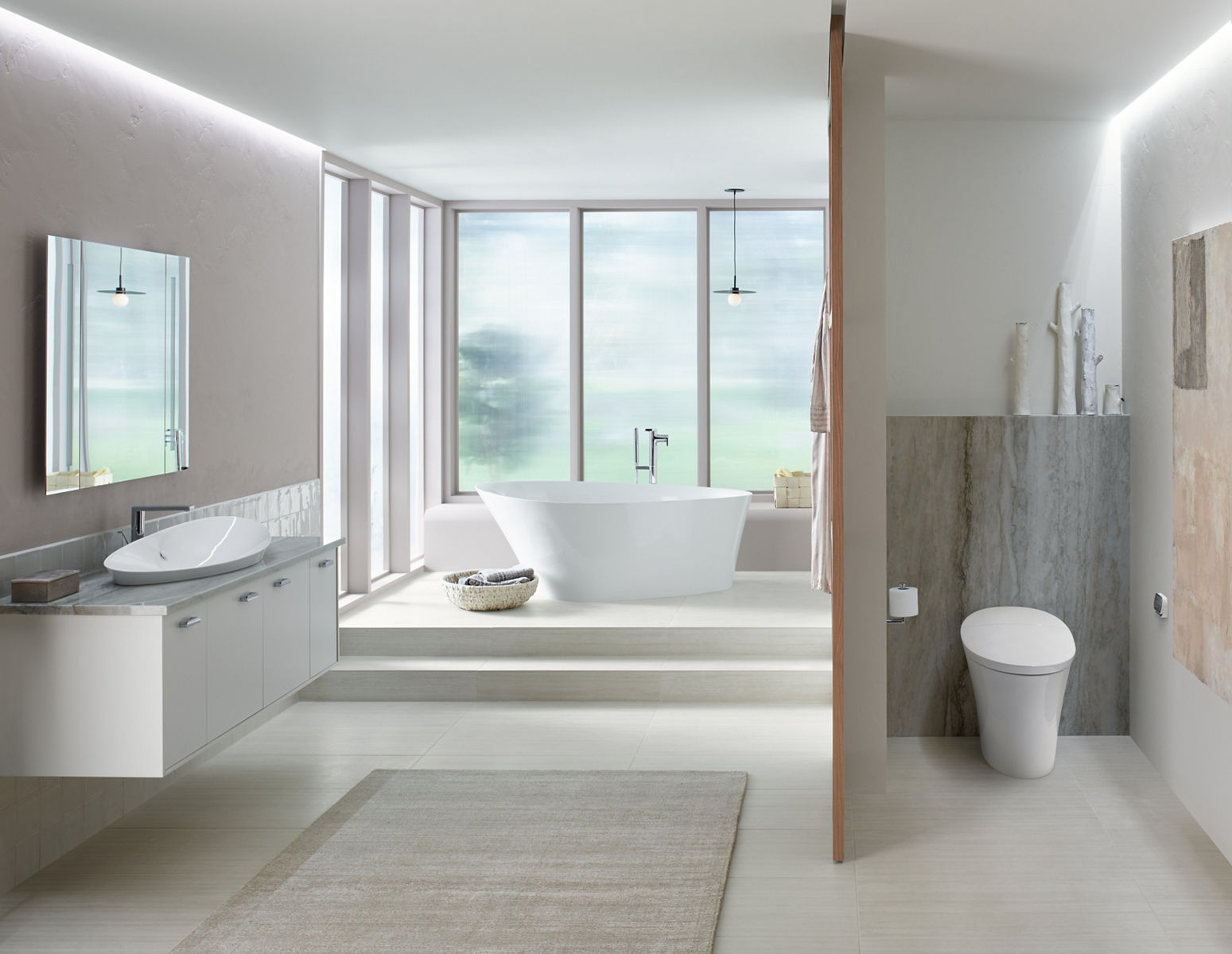 Une salle de bain aérée avec de grandes fenêtres, une baignoire autoportante Veil de KOHLER, un meuble-lavabo mural avec lavabo en surface Veil et une alcôve séparée avec toilette intelligente Veil.