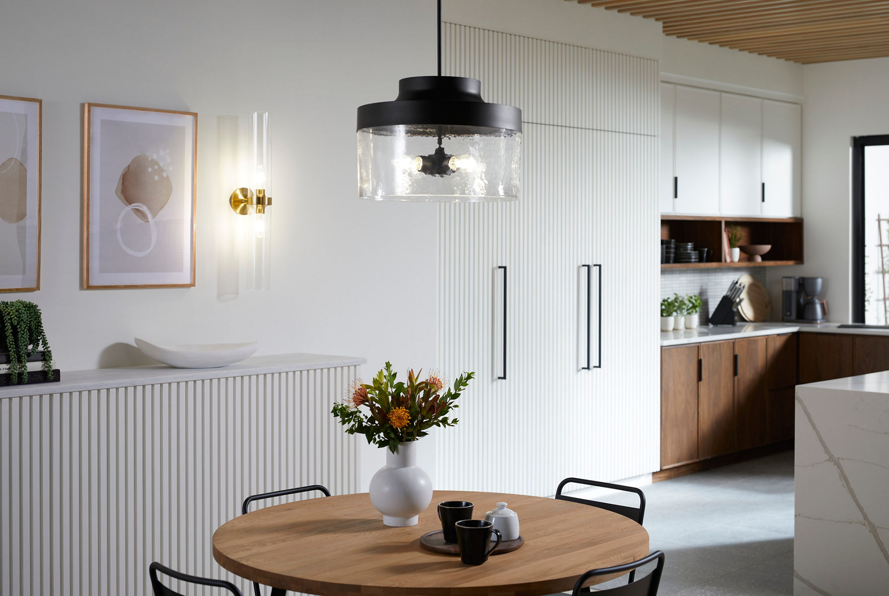 A hanging light with a matte black base and wavy glass shroud.