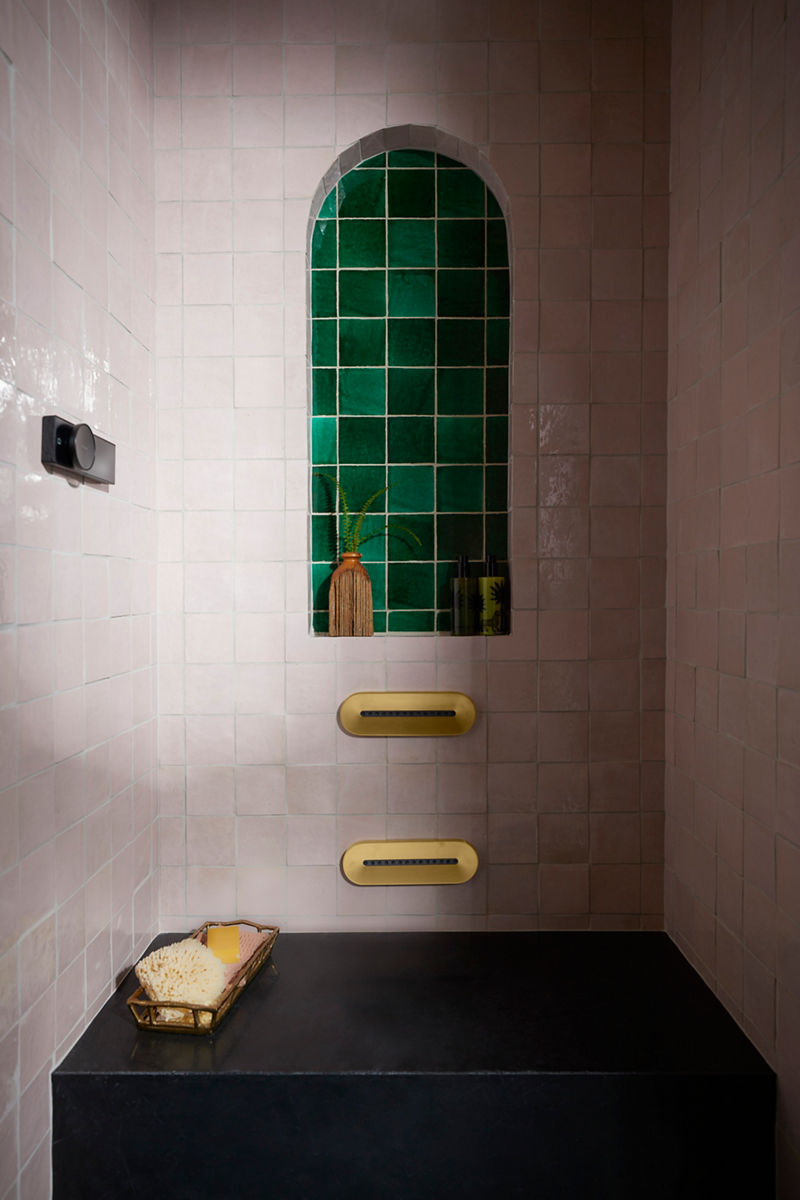 Image de la zone de douche dans la salle de bain conçue par Justina Blakeney pour la collection Heritage Color de Kohler. L’image met l’accent sur les commandes de douche et les jets corporels Anthem, installés contre les murs aux tuiles colorées.