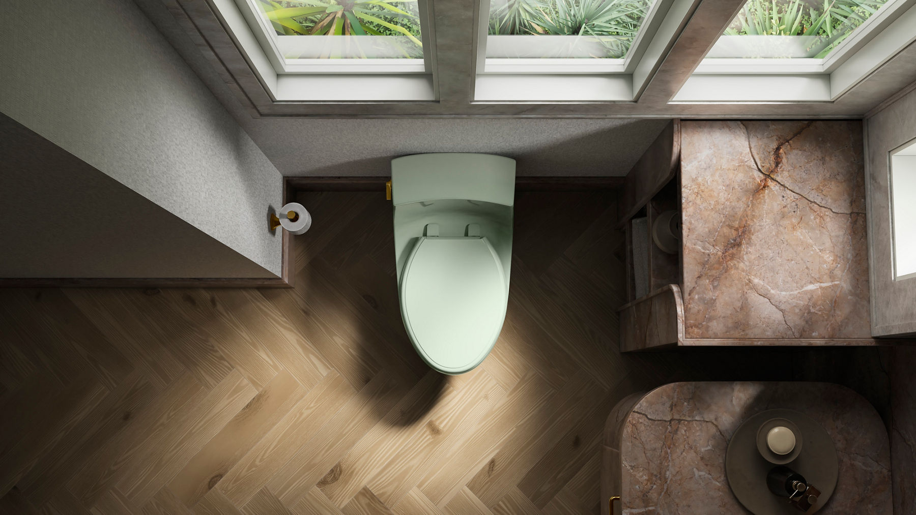 Vue aérienne d’une toilette vert pâle dont le couvercle est fermé. À gauche de la toilette se trouve du papier hygiénique et deux fenêtres se trouvent derrière.