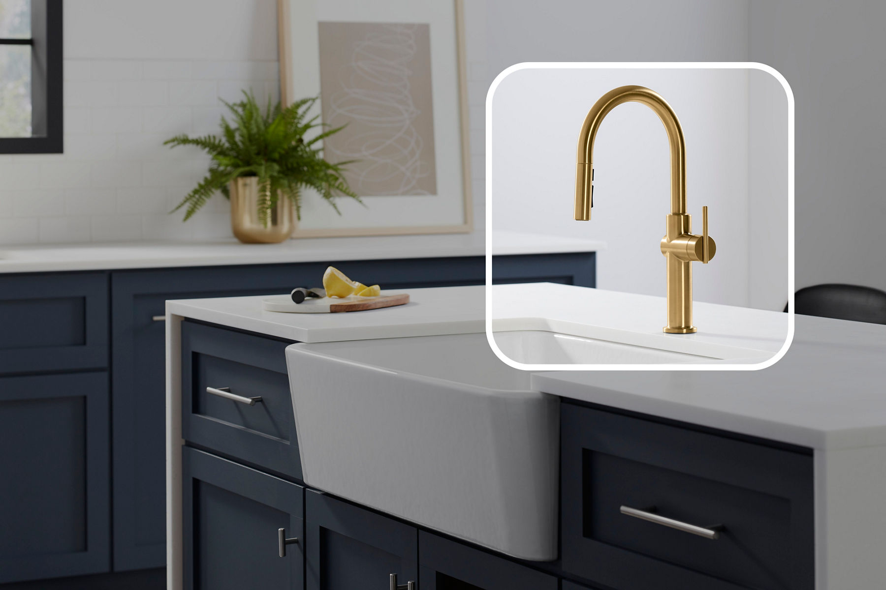 A kitchen island with a farmhouse sink and brushed brass faucet with a lightened graphic square placed over the faucet to give it emphasis.