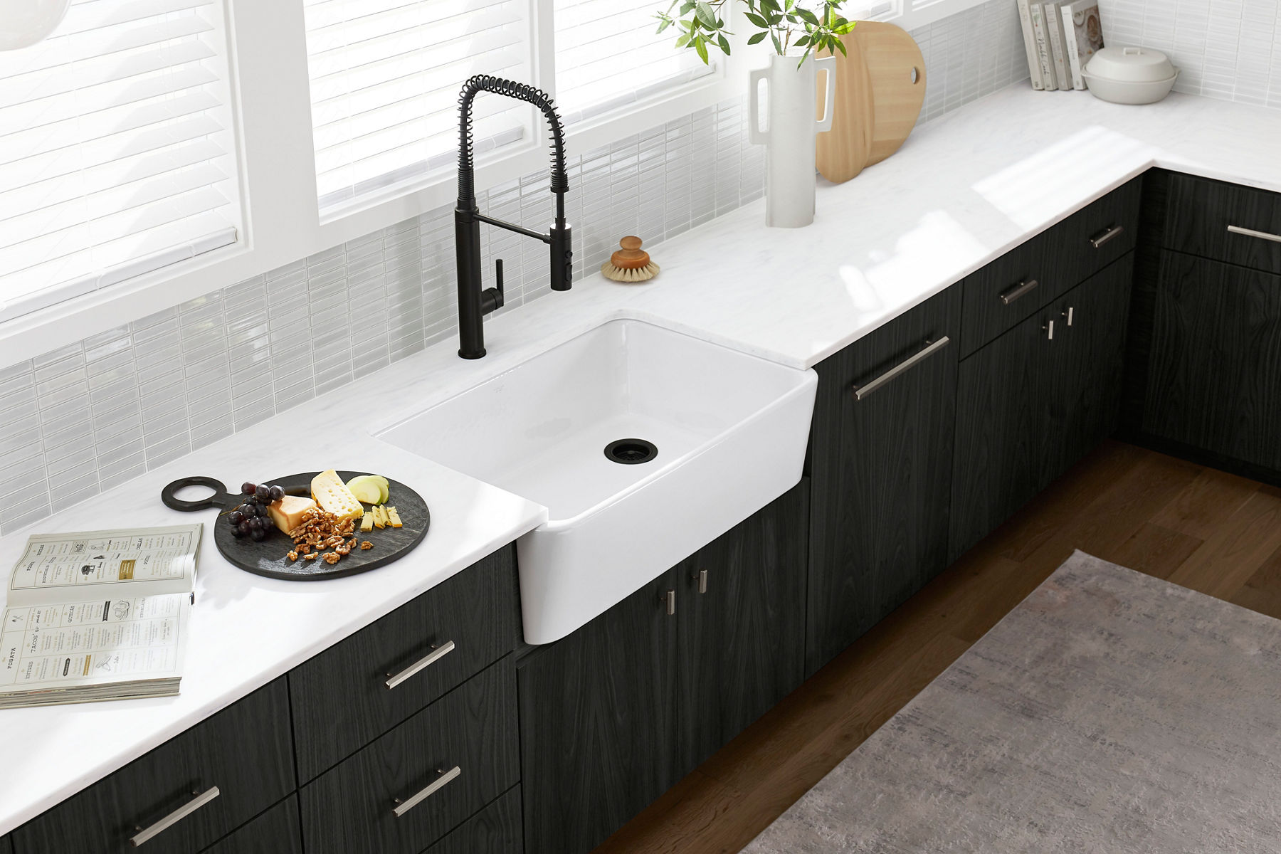 A white sink, countertop, and backsplash with a matte black semi-professional faucet.