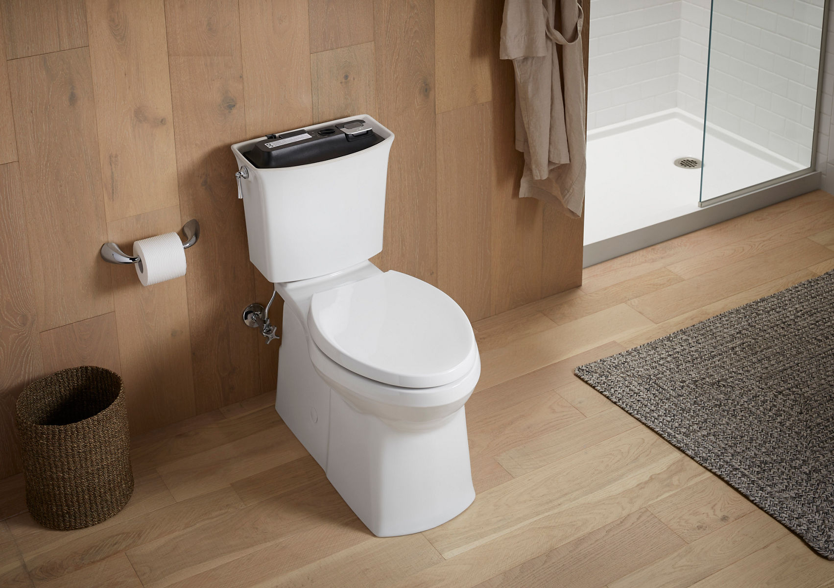 A person adds cleanser to a KOHLER ContinuousClean system installed in a white toilet tank.