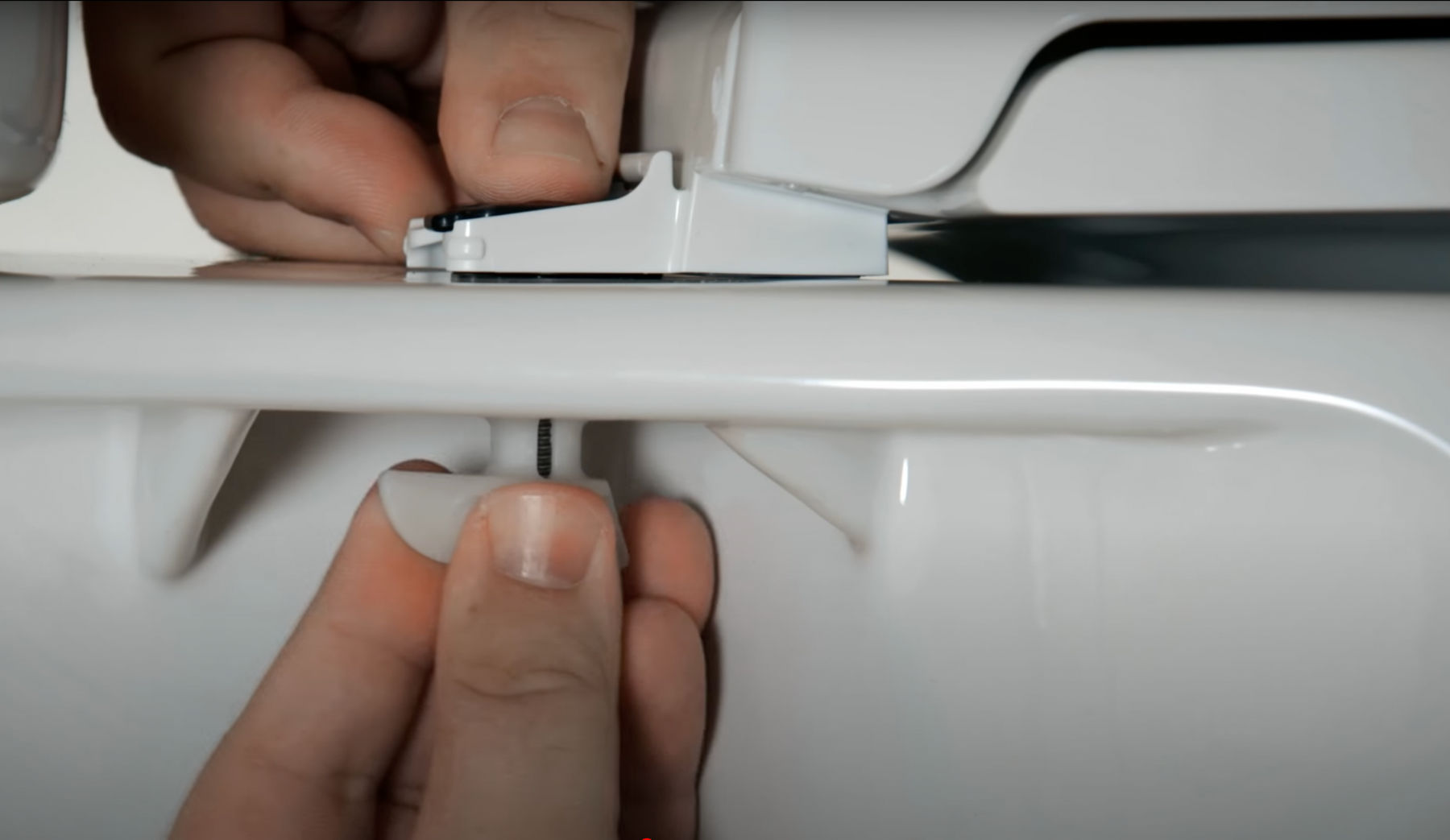 Close up detail of the fasteners of a toilet seat being installed on a toilet