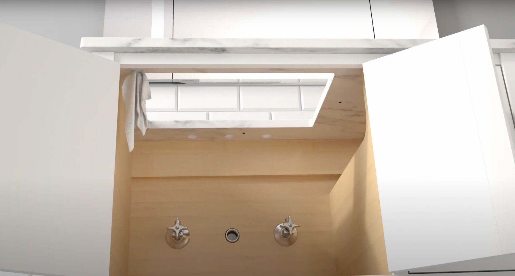 A view from inside a bathroom vanity cabinet looking up at a tile backsplash through a hole in the countertop where a sink will be installed.