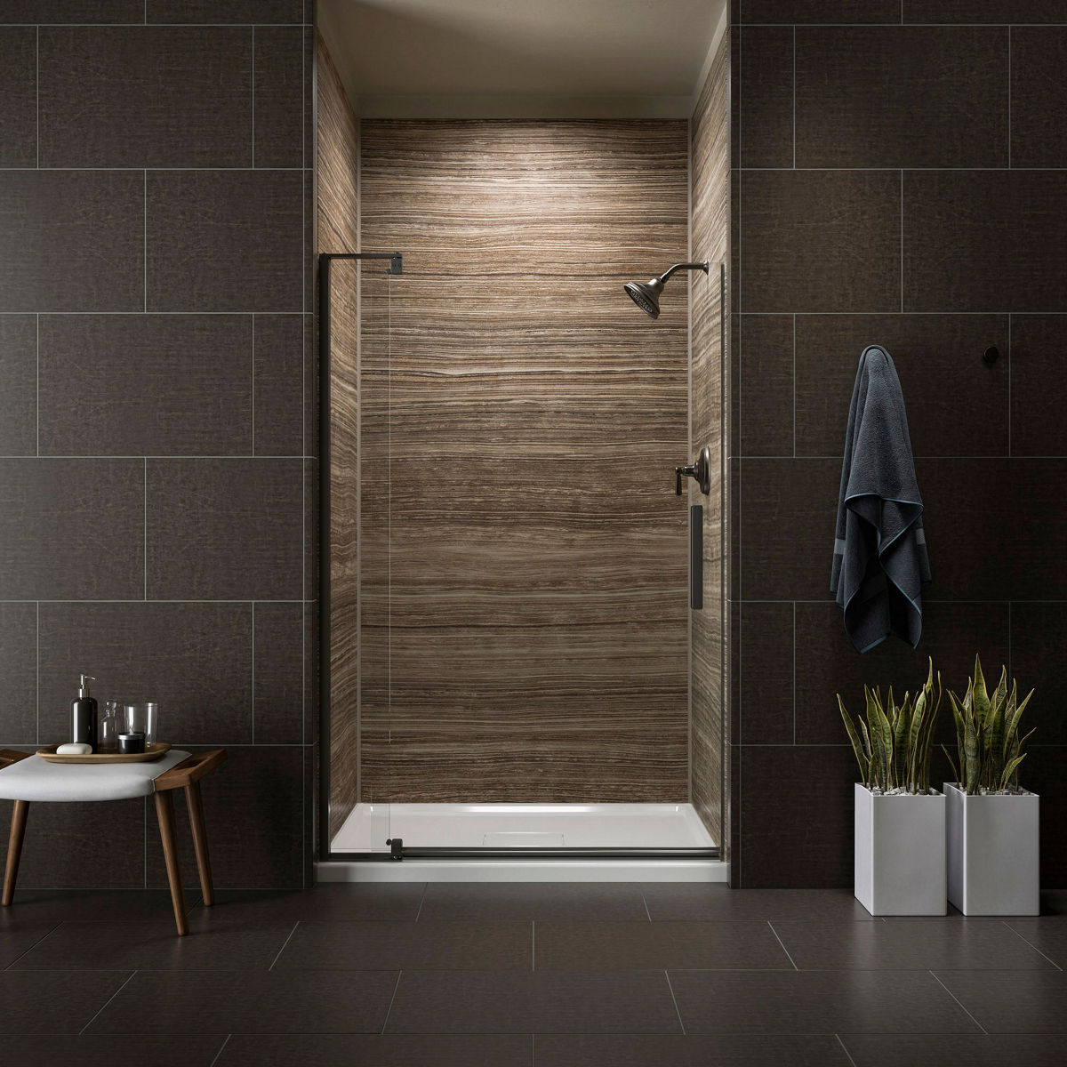 A white bathtub with brushed nickel valve trim and beige mottled tile walls.