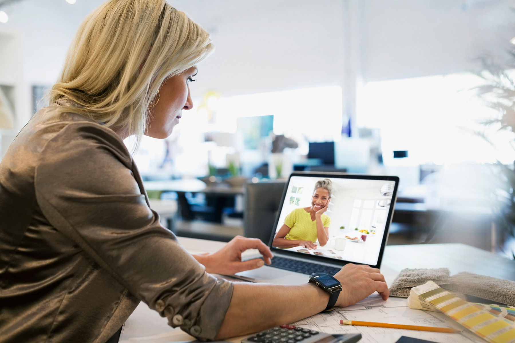 A woman working with an interior designer on her computer screen.