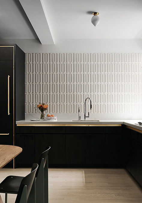 Modern kitchen interior with Ann Sacks wall tile and black cabinetry with sink.
