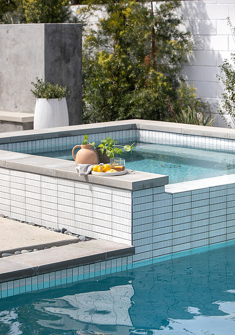 Outdoor pool and hot tub with Ann Sacks tile surrounding the hot tub.