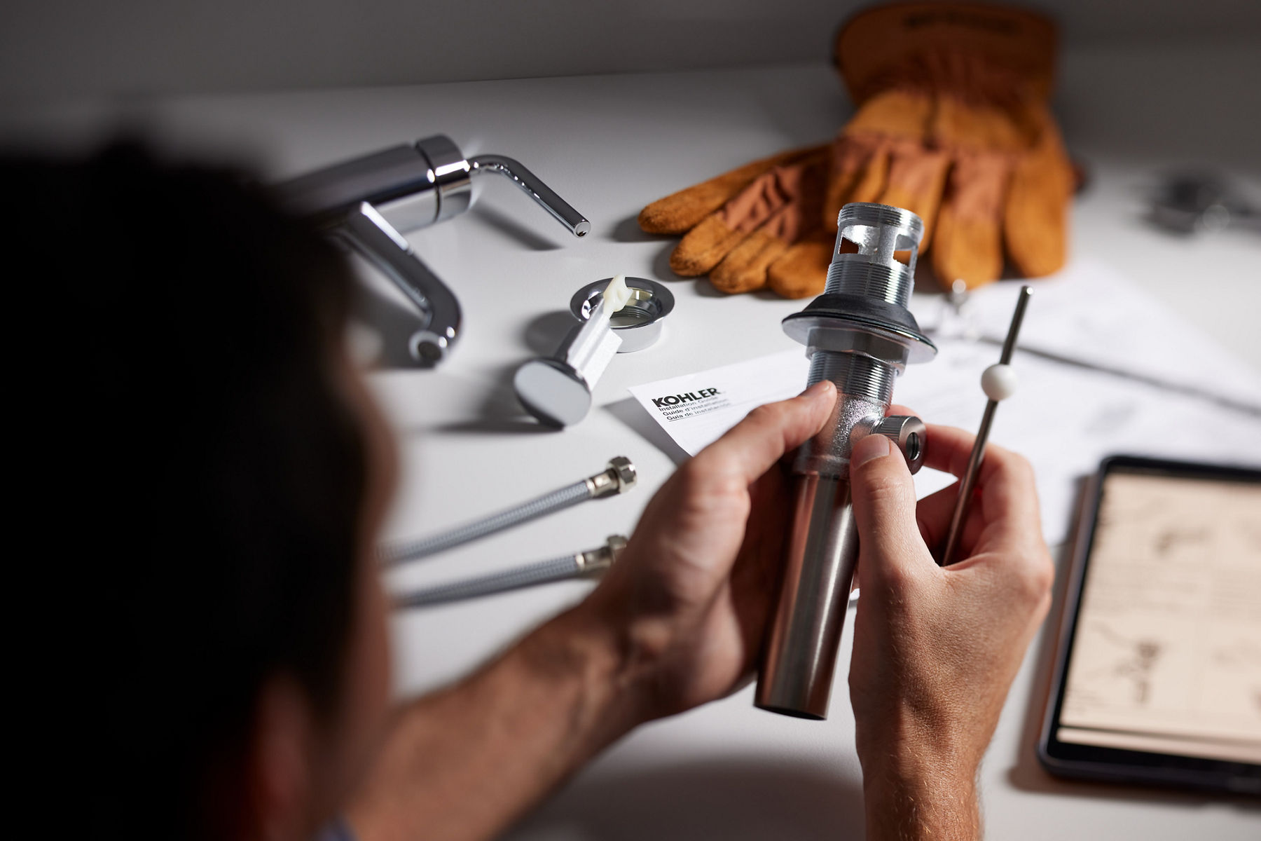 A person assembles a KOHLER single-lever handle bathroom faucet.