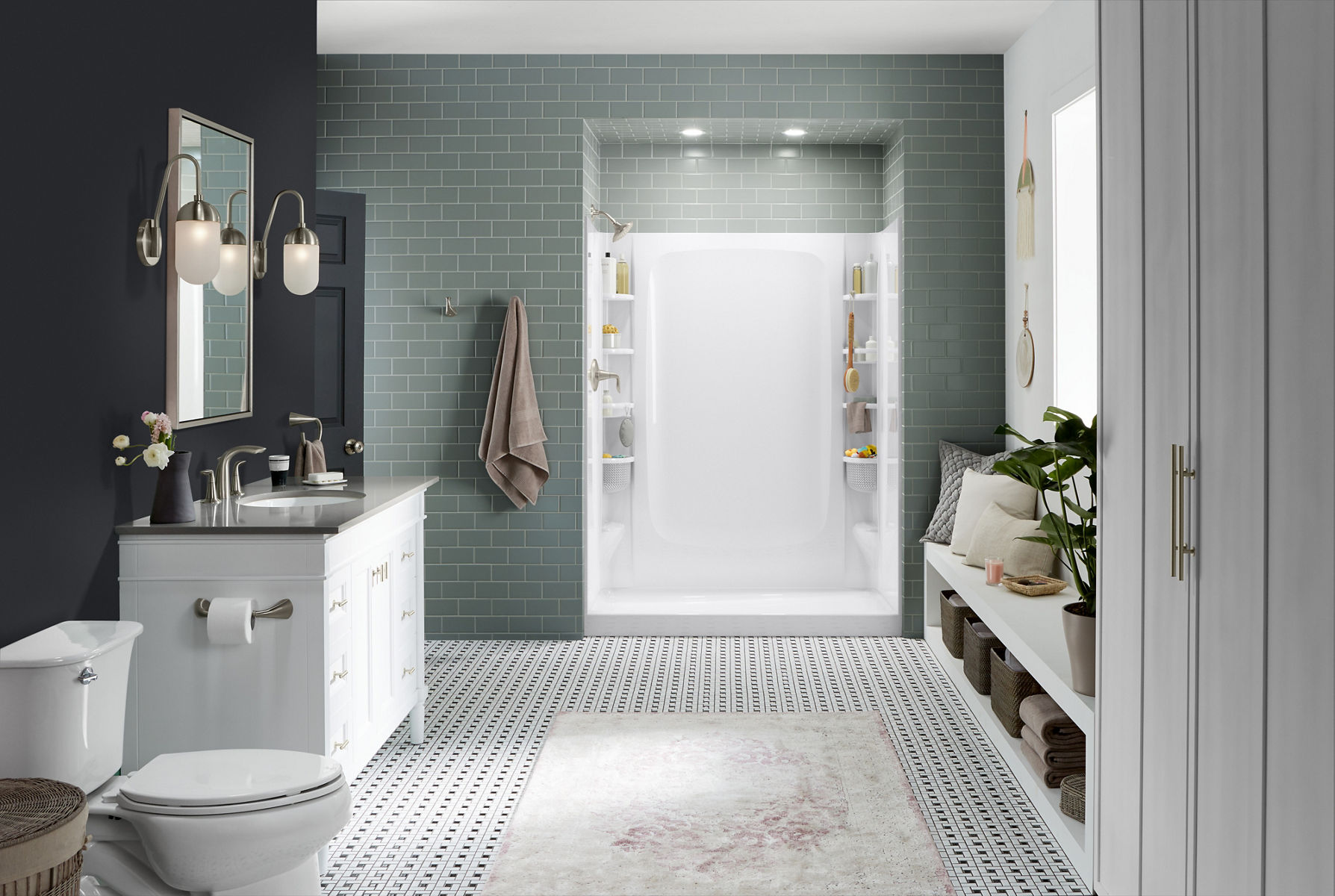 A white three-wall shower stall with white base installed in a room with gray tile.