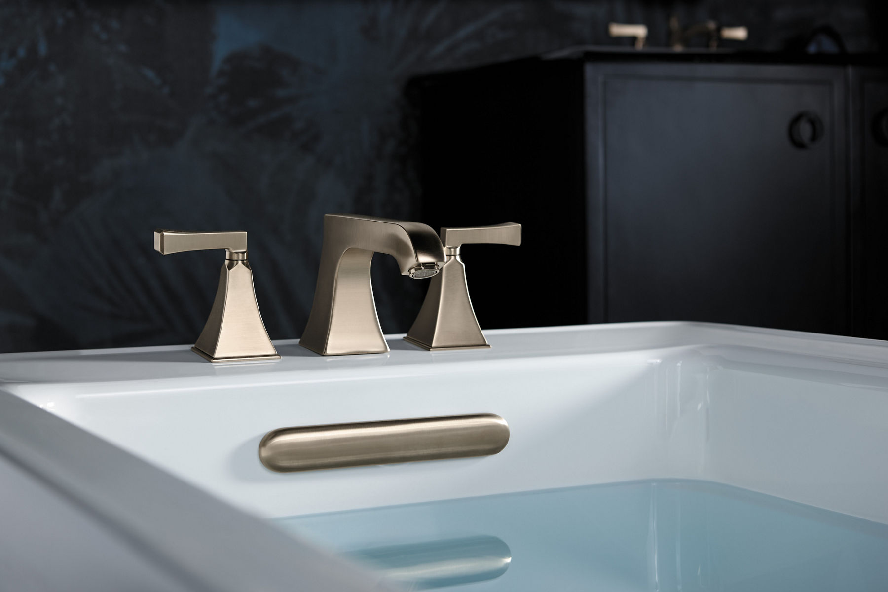 Water fills a white KOHLER Archer freestanding bath Memoirs Stately deck mount bath faucet and Clearflo overflow drain.