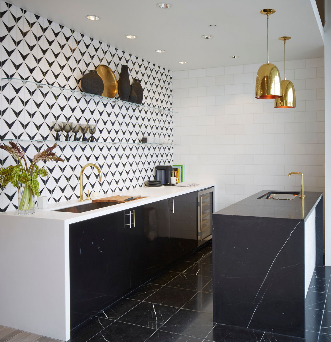 Ann Sacks Austin tile showroom interior view of modern kitchen design with mosaic tile backsplash and black stone island