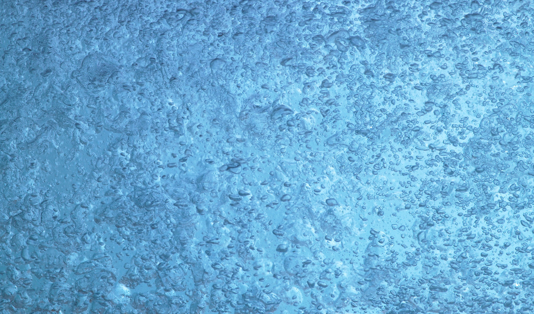 Blue water inundated with air bubbles from a KOHLER bath with BubbleMassage hydrotherapy.