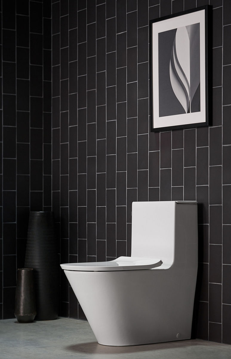 A Brazn one-piece toilet in white set against a tiled wall.