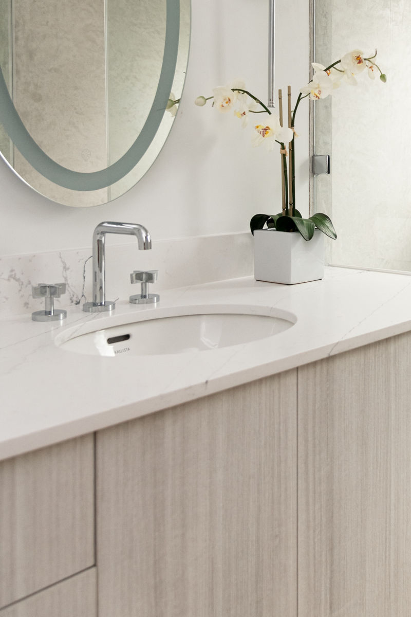 A white Perfect Soft Oval sink in a white counter top with a chrome widespread faucet.